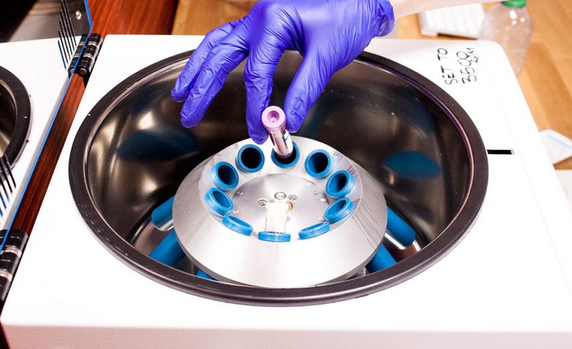 A vile being put into a centrifuge machine