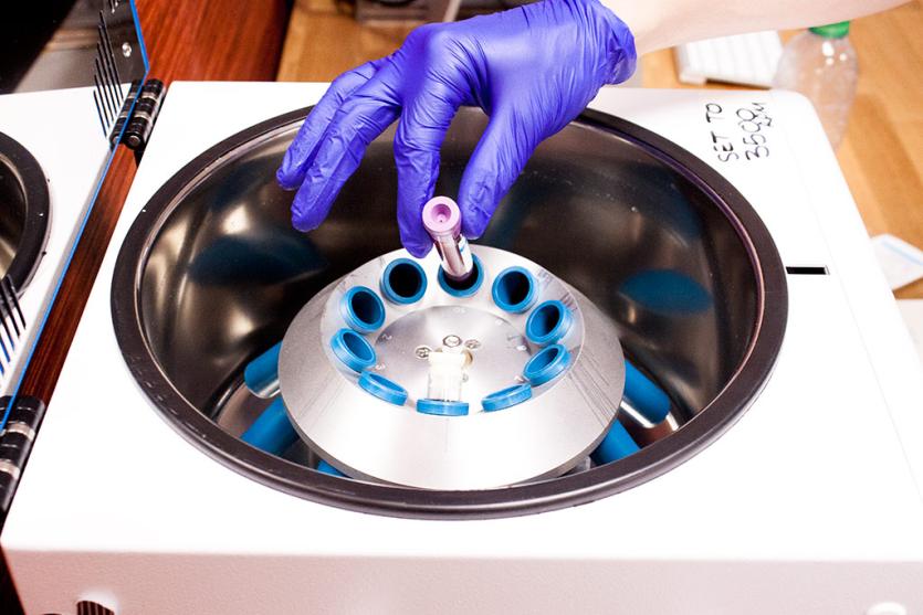 A vile being put into a centrifuge machine